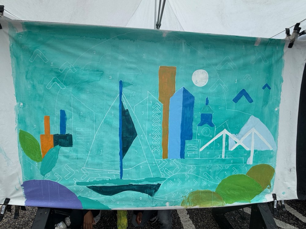 A finished mural panel showing sailboats and the Baltimore skyline in teal and blue